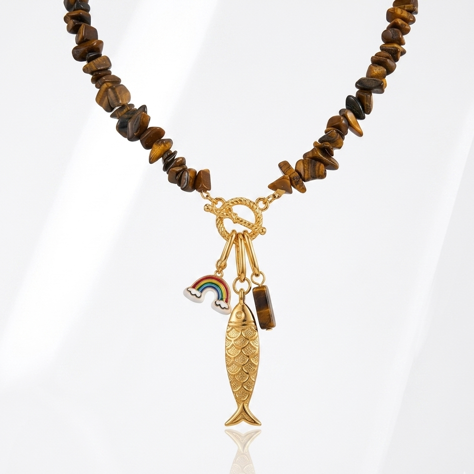 Necklace with brown beaded chain and gold fish charm on a white background